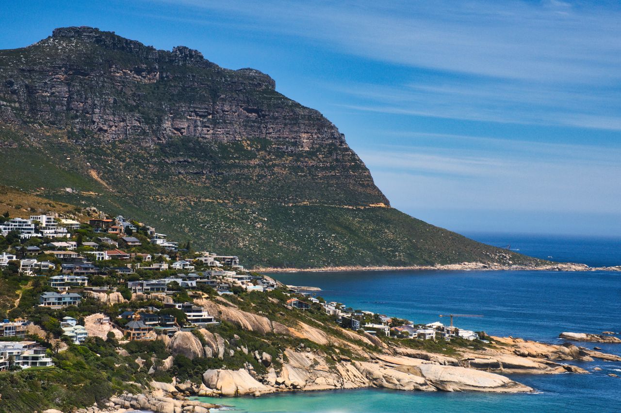 Breathtaking coastal view of Cape Town, showcasing rugged mountains and azure ocean waters.