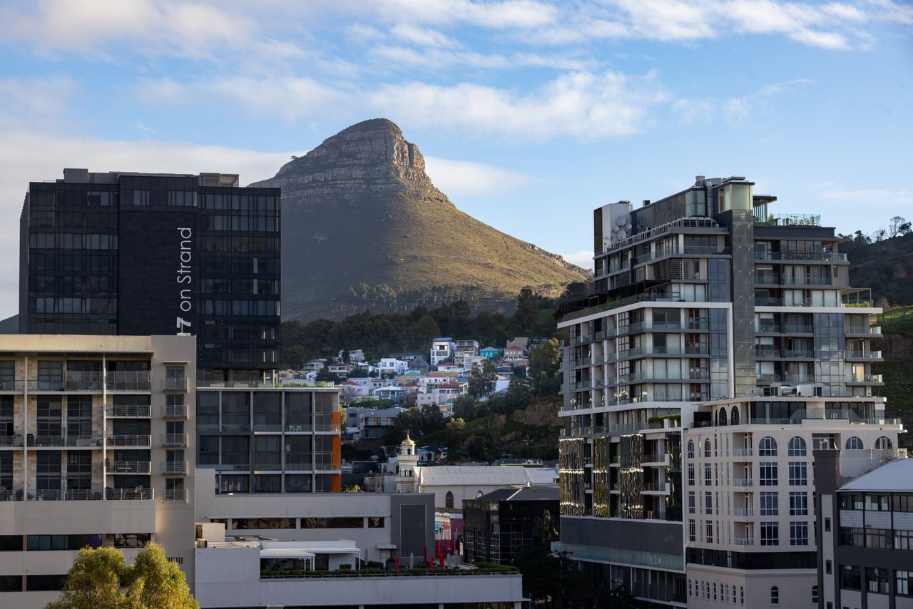 Scenic urban view of Cape Town with Lion's Head mountain in the background under a clear blue sky.